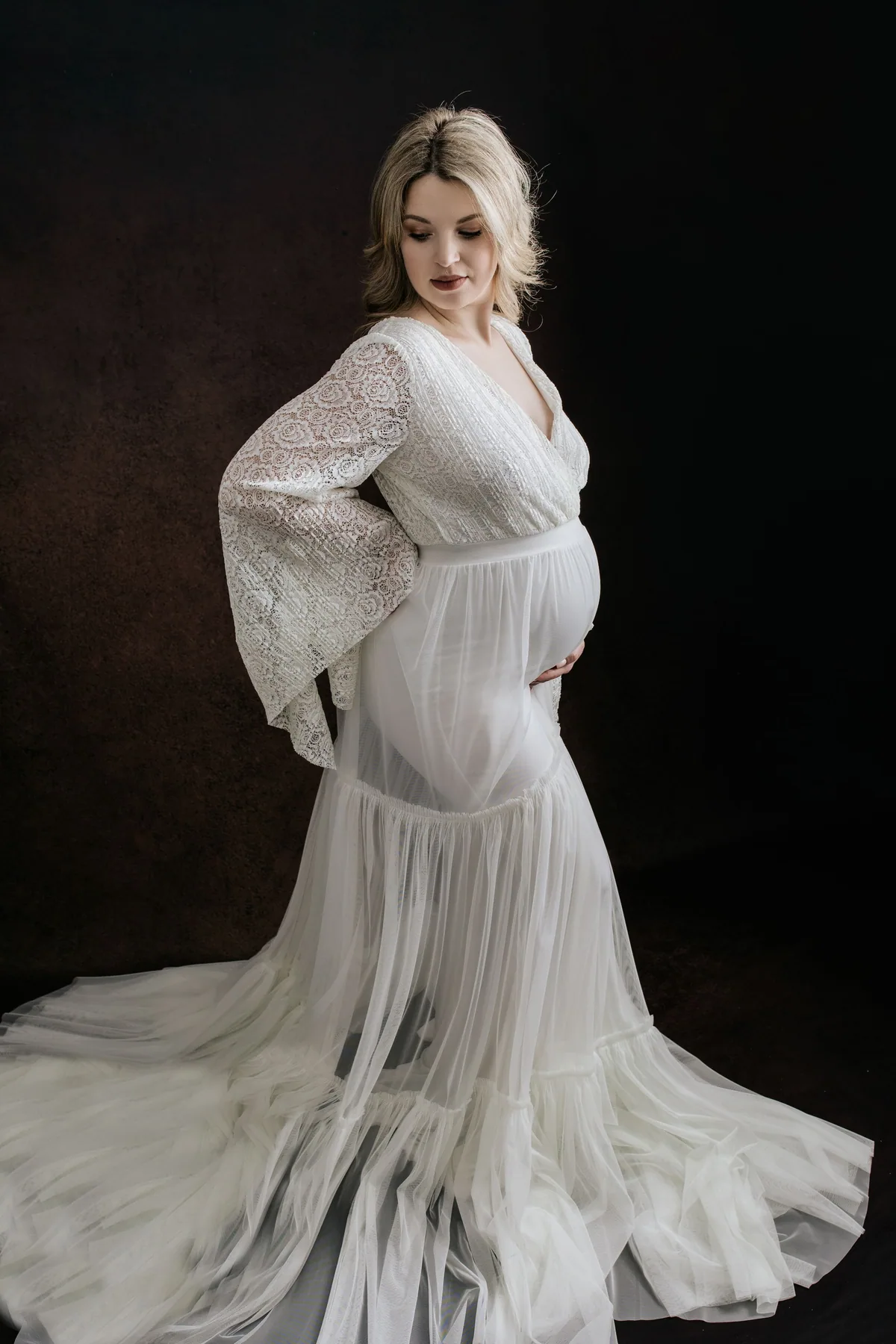 Portrait de future maman en robe blanche au studio