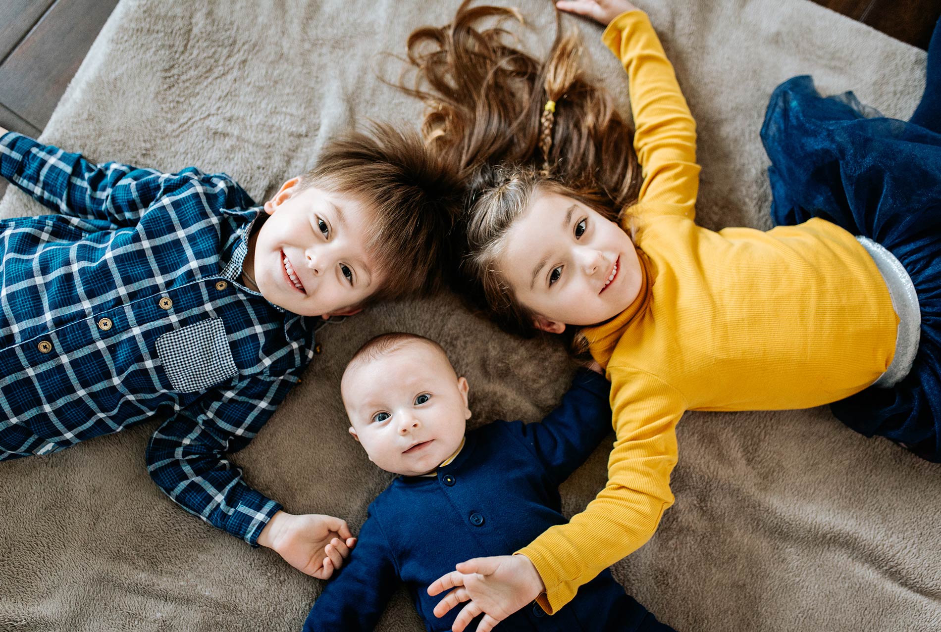 Fratrie photographiée en extérieur pendant une séance famille
